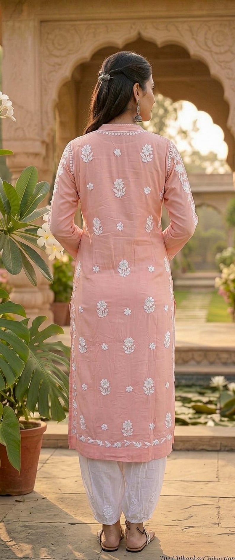 Puede incluir: Una kurta rosa claro bordada con patrones florales blancos. La t&uacute;nica de manga larga se combina con pantalones blancos. El conjunto forma parte de un estilo indio tradicional, perfecto para uso casual o festivo.