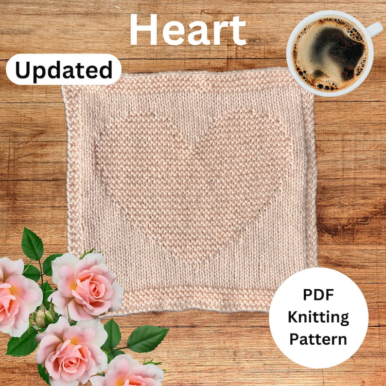 May include: A knitted heart-shaped dishcloth in a light pink color. The dishcloth is on a wooden surface with a cup of coffee and a bouquet of pink roses. The text "Heart" and "Updated" are visible in the image. The text "PDF Knitting Pattern" is also visible in the image.