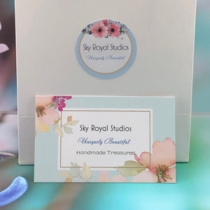 May include: A light blue card with a floral design and the text "Sky Royal Studios Uniquely Beautiful Handmade Treasures".