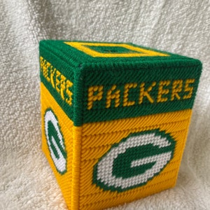 May include: Green and yellow tissue box cover with the Green Bay Packers logo and the word "Packers" on the front.