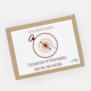 Könnte beinhalten: Eine rechteckige Box aus braunem Karton mit einem weißen Etikett. Das Etikett zeigt eine Kompassillustration und den Text "MEIN INNERER KOMPASS". Darunter steht "55 BILDKARTEN FÜR PSYCHOTHERAPIE, BERATUNG UND COACHING".