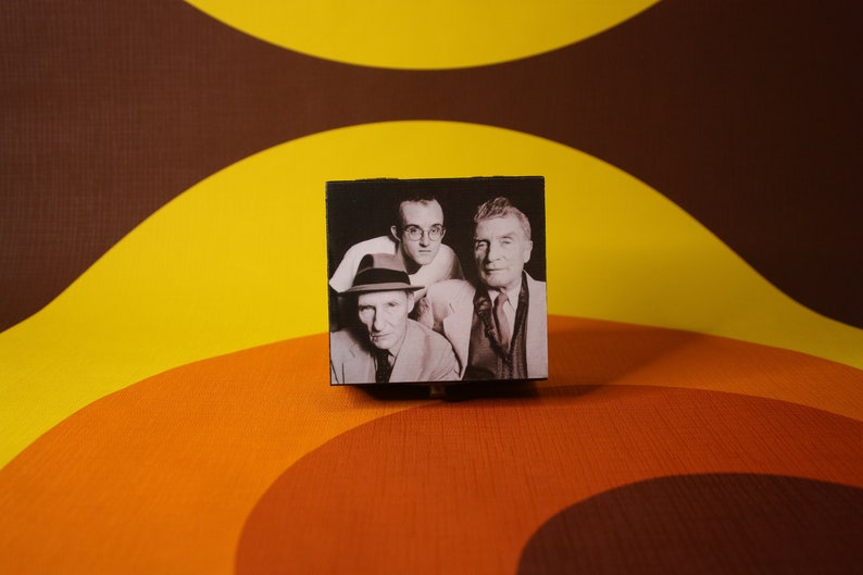 May include: A black and white photo of three men in suits and hats. The photo is framed in a black box.
