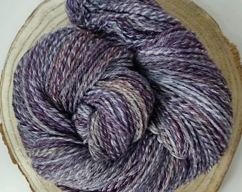 Soft, hand-spun yarn made of hand-dyed merino wool, suitable for knitting, crocheting, and weaving