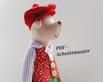 May include: A red and white striped shirt, red vest with floral print, green pants, and red shoes. The doll is wearing a red hat and has a white face. The text "PDF - Schnittmuster" is visible in the image.