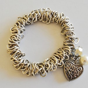 Silver chain mail, stretch bracelet with a Repoussé heart charm.  Silvery steel link very stretchy 60s, 70s charming Hippie, Boho, bracelet.