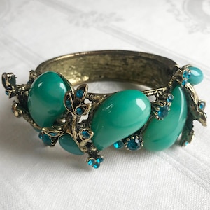 May include: A white ceramic mug with a black handle and the text "But First, Coffee" in a black, bold font. The mug is sitting on a wooden surface.