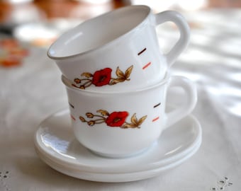 Set of 2 Arcopal tea cups and saucers.  Tempered white, milk glass, with a floral pattern on one side and stripes on the other.  1970s cups.