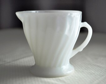 Anchor Hocking, small milk glass jug.  Diagonal ribbed pedestal jug.  Sturdy, heat resistant, great shaped, handy little jug.  3 quart cup.