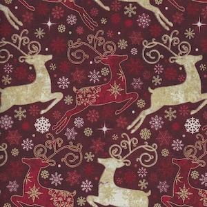 Puede incluir: Una tela festiva con un patrón repetido de renos y copos de nieve. Los renos son dorados y rojos, con cornamentas ornamentadas y detalles decorativos. Los copos de nieve son dorados, rojos y blancos, sobre un fondo burdeos oscuro.