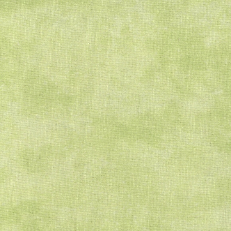 May include: A close-up of a light green fabric with a textured appearance. The fabric has a subtle, mottled effect, with variations in the green hue. The material appears to be a woven textile, possibly linen or cotton, suitable for various craft projects.