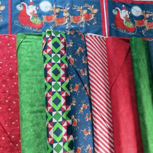 May include: Assortment of fabric scraps in various Christmas patterns, including red and green plaid, blue with reindeer, and red with white stars.