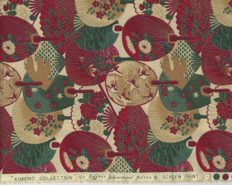 May include: A fabric with a repeating pattern of red, green and gold fans. The fabric has a cream background and the text "KIMONO COLLECTION" by Hoffman International Fabrics &copy; SCREEN PRINT.