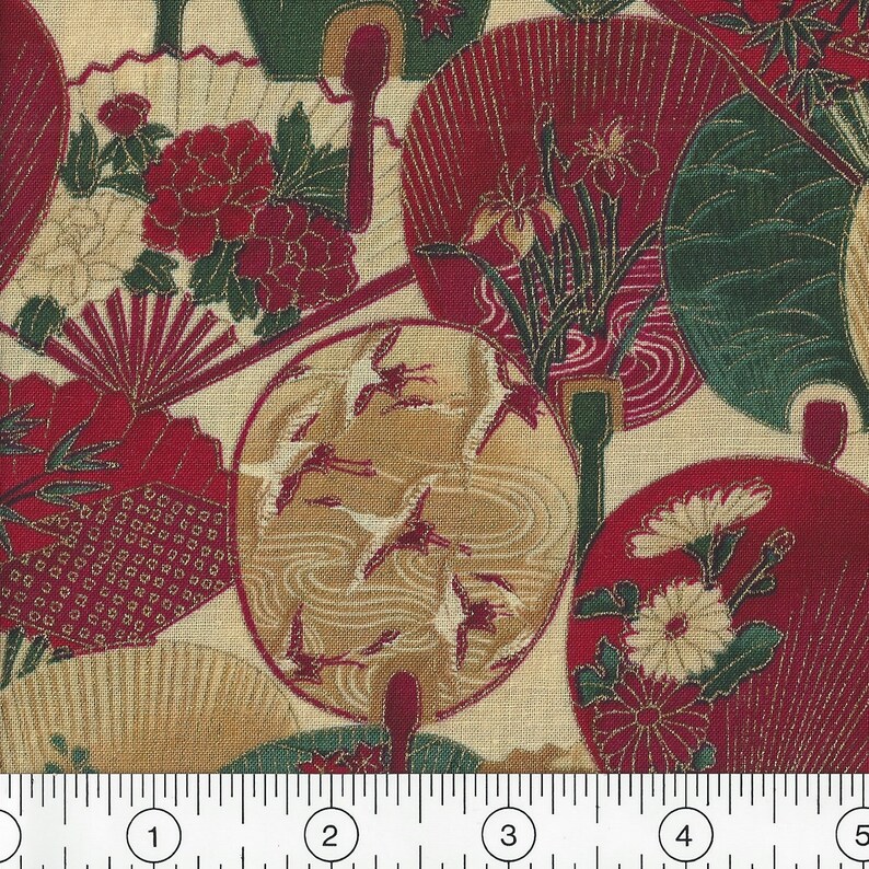 May include: Red and gold fabric with a repeating pattern of fans, flowers, and birds. The fabric is on a cream background and has a ruler for scale.