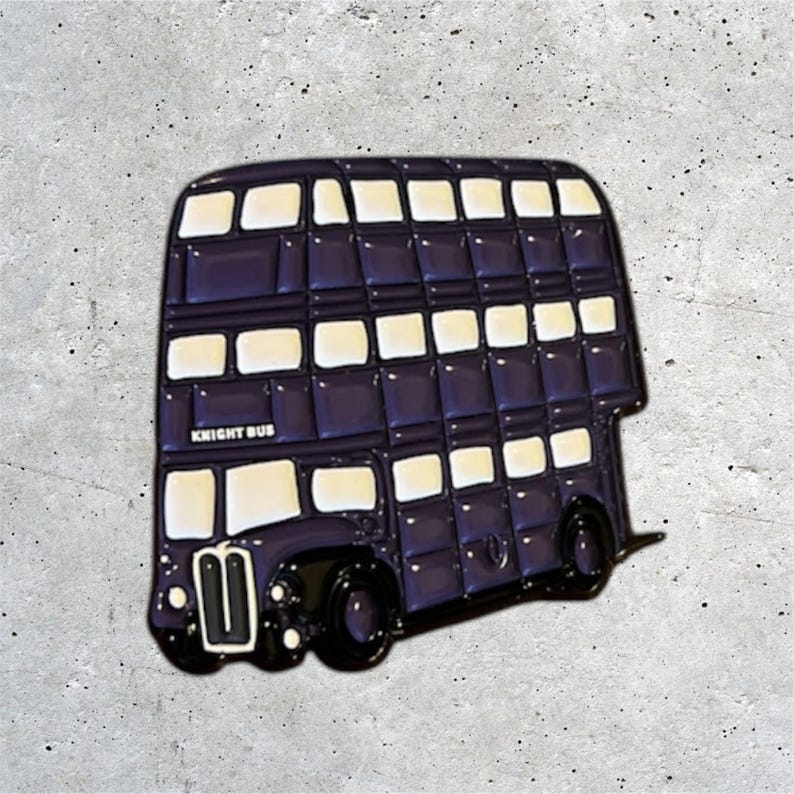 K&ouml;nnte beinhalten: Eine lilafarbene Doppeldeckerbus-Enamel-Anstecknadel mit wei&szlig;en Fenstern und dem Schriftzug "Knight Bus" an der Seite.