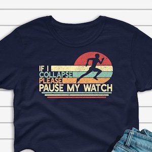 May include: Navy blue t-shirt with a retro-style graphic of a runner and the text "If I Collapse Please Pause My Watch".