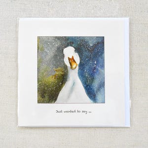 May include: A square greeting card featuring a watercolor painting of a white goose with a curious expression. The background has blue, green, and white splatters. The text "Just wanted to say..." is written at the bottom.