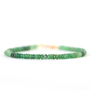 May include: A delicate emerald green gemstone bracelet with a gold clasp.