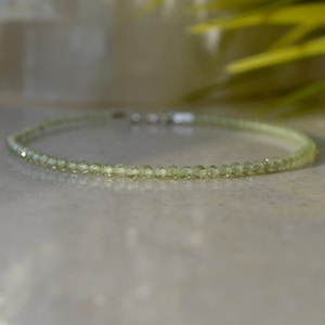 May include: A delicate green gemstone bracelet made of small, faceted beads. The bracelet is simple and elegant, perfect for everyday wear.