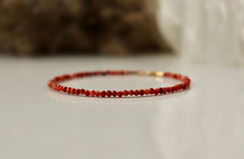 Puede incluir: Un delicado brazalete de piedras preciosas rojas con peque&ntilde;as cuentas redondas. El brazalete est&aacute; hecho con un cierre de oro.
