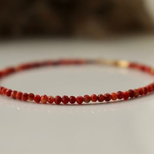 Puede incluir: Un delicado brazalete de piedras preciosas rojas con peque&ntilde;as cuentas redondas. El brazalete est&aacute; hecho con un cierre de oro.