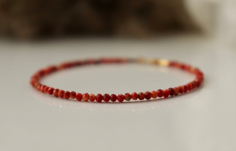 Puede incluir: Un delicado brazalete de piedras preciosas rojas con peque&ntilde;as cuentas redondas. El brazalete est&aacute; hecho con un cierre de oro.