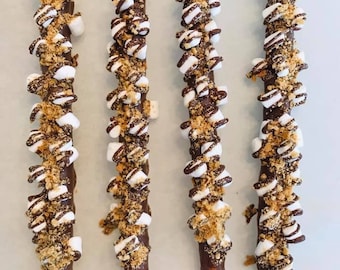Puede incluir: Cuatro palitos de pretzel cubiertos de chocolate, cubiertos con mini malvaviscos, migas de galleta graham y un chorrito de chocolate.