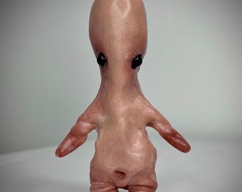 Curiosidad hecha a mano en arcilla polimérica: escultura artística de una criatura carnosa.