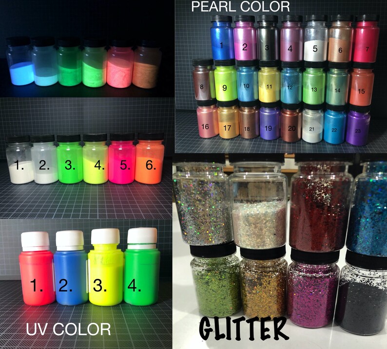 May include: Assortment of small glass jars filled with various colors of glitter and pearl pigment powder. The jars are labeled with numbers 1 through 23 for pearl pigment and 1 through 4 for UV color. The jars are arranged in rows on a black and white grid background.