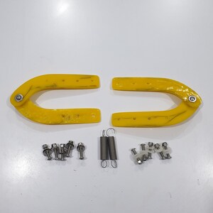 May include: Two yellow plastic U-shaped pieces with holes and a silver hinge. The pieces are for a folding chair. There are also two silver springs and several silver screws and nuts.