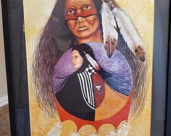 May include: A framed painting depicting a Native American man with long black hair and a feathered headdress. He is wearing a purple and blue shirt and has red and black face paint. The painting is set against a yellow background.