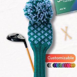 May include: A teal and blue knitted golf club head cover with a pom-pom, a golf club, golf tees, and a golf ball box. The cover has a white floral pattern and the word "Customizable" is displayed.