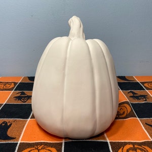 May include: A white ceramic pumpkin, ready to be painted for Halloween decorations.