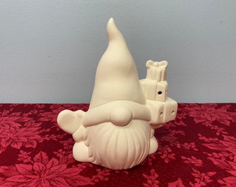Peut inclure: Figurines de gnome en céramique blanche tenant un tas de cadeaux. Le gnome a un chapeau pointu et une longue barbe.