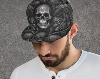 Può includere: Un cappellino da baseball nero e grigio con un motivo dettagliato e ripetitivo di teschi umani. Il design copre l'intera corona e la visiera del cappello, mostrando ombreggiature e texture complesse che creano un effetto visivo scuro.
