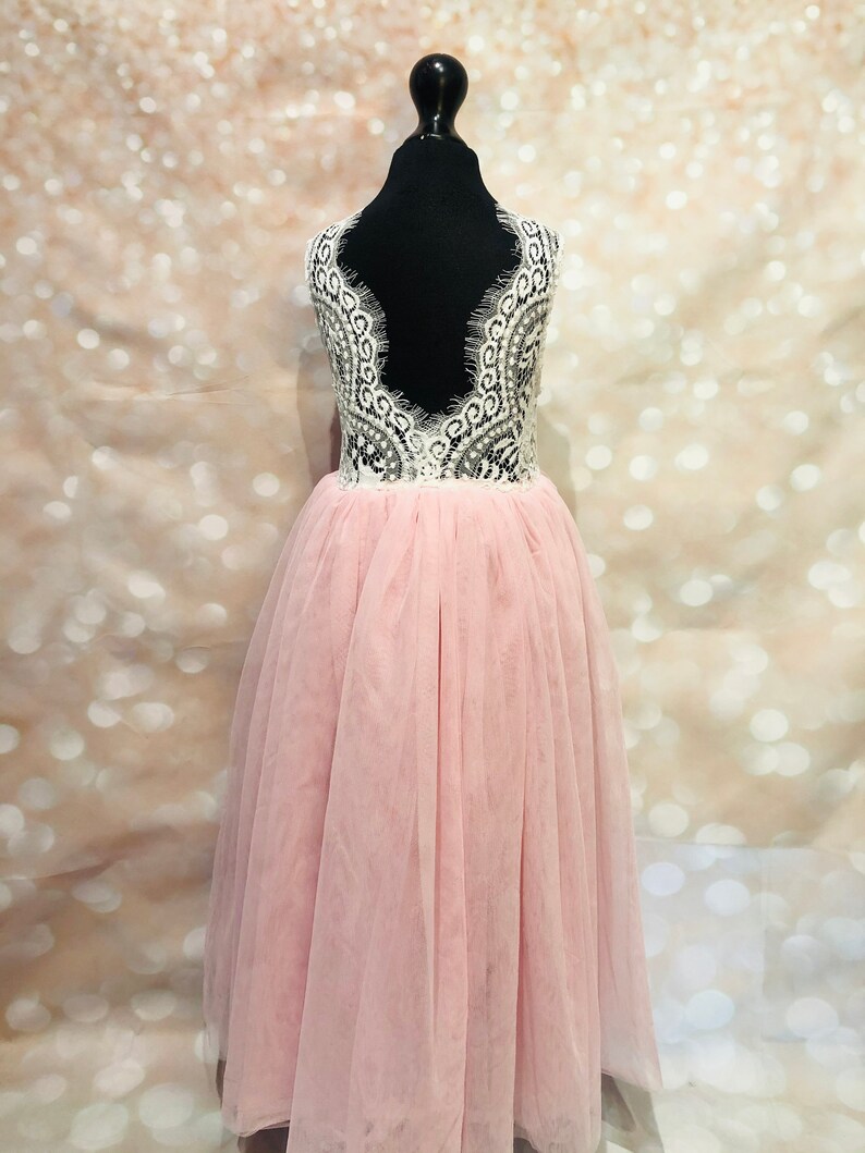 Puede incluir: Un vestido de tul rosa con un corpi&ntilde;o de encaje blanco y una espalda baja. El vestido es sin mangas y tiene una falda completa.