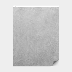 May include: A rectangular, gray, textured paper with a subtle, mottled pattern. The paper has a slightly curled corner, revealing a white backing. The top left corner features a small, black logo.