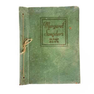 May include: Vintage green scrapbook with the text "Margaret Sangster's SCRAP BOOK" in a decorative frame. The cover is aged with visible wear and tear, and is bound with a string.