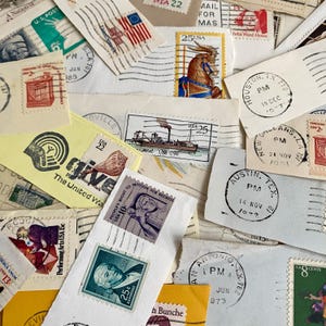May include: A collection of vintage postage stamps and envelope fragments featuring various designs, including a carousel horse, a steamboat, and portraits. The stamps display diverse denominations and postmarks from cities like Houston and Austin.