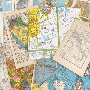 May include: A collection of vintage maps, featuring various regions and countries. The maps display a range of colors, with detailed geographical features and text labels. Some maps are open, while others are partially visible, creating a layered effect.