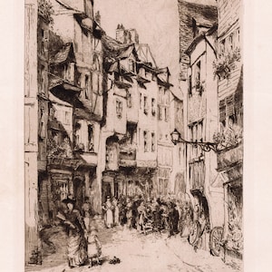 May include: A black and white etching of a narrow street in a European city. The street is lined with tall, narrow buildings with steeply pitched roofs. There are people walking in the street, and a few carts are parked on the side.
