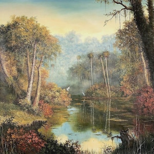 May include: An oil painting of a tranquil swamp scene. The artwork shows a calm river reflecting the surrounding trees and sky. The colour palette includes greens, browns, and blues, with hints of red and yellow. Two white birds fly over the water.