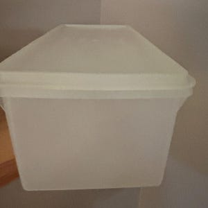 May include: A rectangular, semi-translucent white plastic storage container with a matching fitted lid. The container features a smooth, minimalist design with a slightly flared rim at the top, providing a clean and functional storage solution.