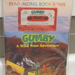 May include: A red cassette tape with the title "GUMBY A Wild West Adventure" and a 24-page full-color book featuring GUMBY in a yellow jeep. The book and tape are packaged together in a clear plastic bag.