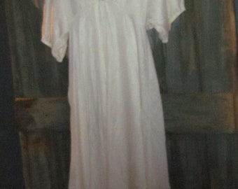May include: A white, long-sleeved, cotton nightgown with a lace trim around the neckline.