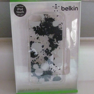 May include: Clear Belkin iPod touch 5th gen case with a black and white splatter design. The case is in its original packaging, which features the Belkin logo and the words "Shield Splatter".