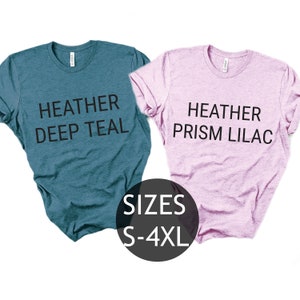 Puede incluir: Dos camisetas, una azul verdosa y otra lila, con el texto "Heather Deep Teal" y "Heather Prism Lilac" impreso en ellas. Tallas S-4XL.