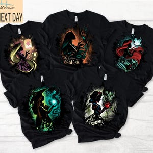 May include: Black t-shirts featuring colorful illustrations of fairytale characters. Designs include a princess with a lantern, a silhouette with scissors, a mermaid, a witch with a glowing orb, and Snow White with an apple.