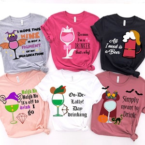 May include: Six different t-shirts with various designs featuring wine glasses, beer mugs, and other drinking-related imagery. The shirts are in different colors, including pink, gray, white, and black.