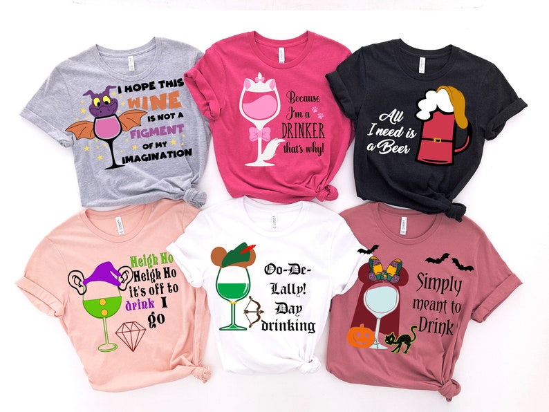 May include: Six different t-shirts with various designs featuring wine glasses, beer mugs, and other drinking-related imagery. The shirts are in different colors, including pink, gray, white, and black.