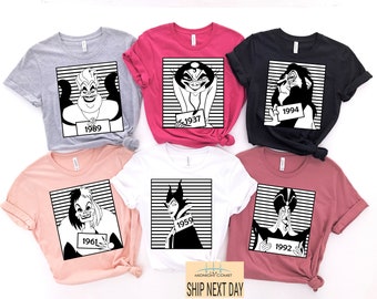 May include: Six different t-shirts featuring Disney villains in a mugshot style. Each shirt has a different villain and a year printed on it. The shirts are in various colors, including gray, pink, black, white, and maroon.